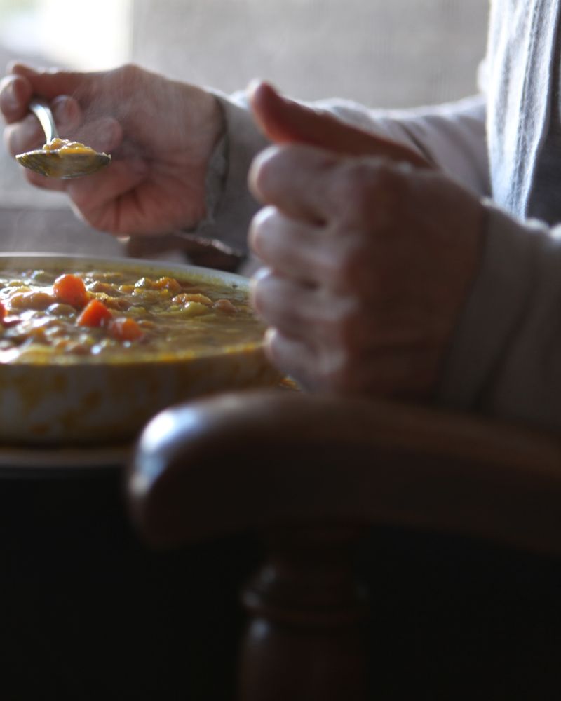 Steam rising from a bowl of soup in winter window light